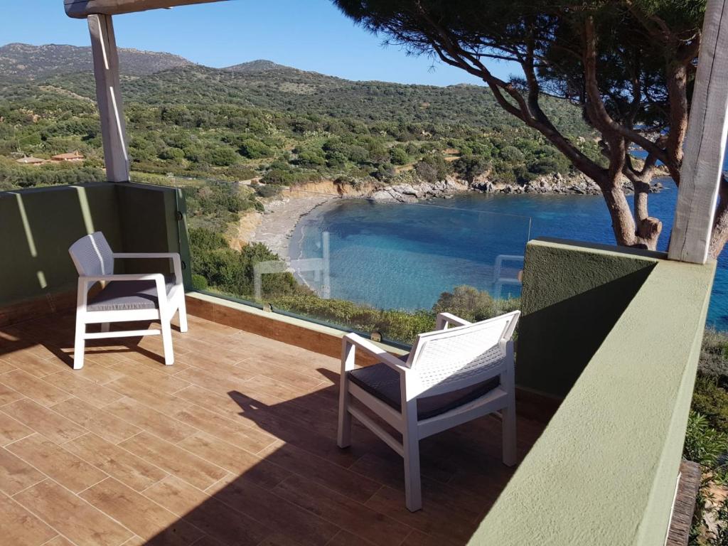 balcón con 2 sillas y vistas a la playa en Accu is Prezzus tipo D1 fronte mare en Villasimius