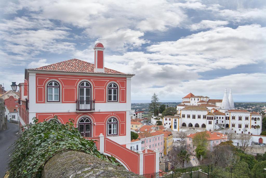 un edificio rosso e bianco in cima a una città di Villa Bela Vista a Sintra