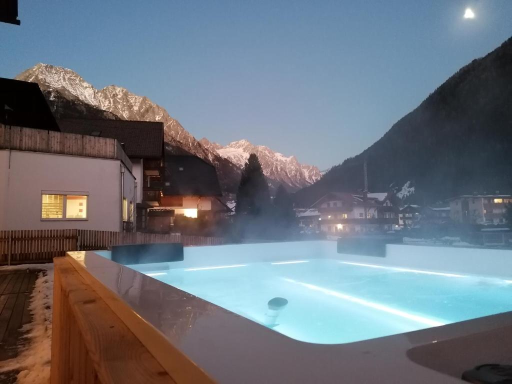 a large swimming pool with mountains in the background at Apartments Rainer in Anterselva di Mezzo