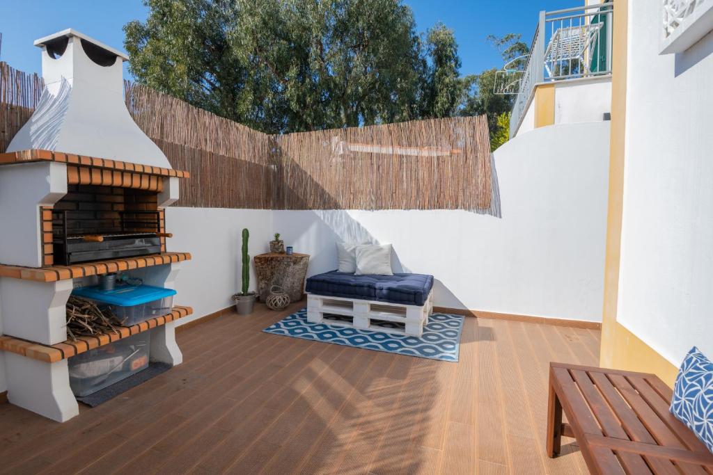 a patio with a bench and a wooden deck at MilDreams House in Vila Nova de Milfontes
