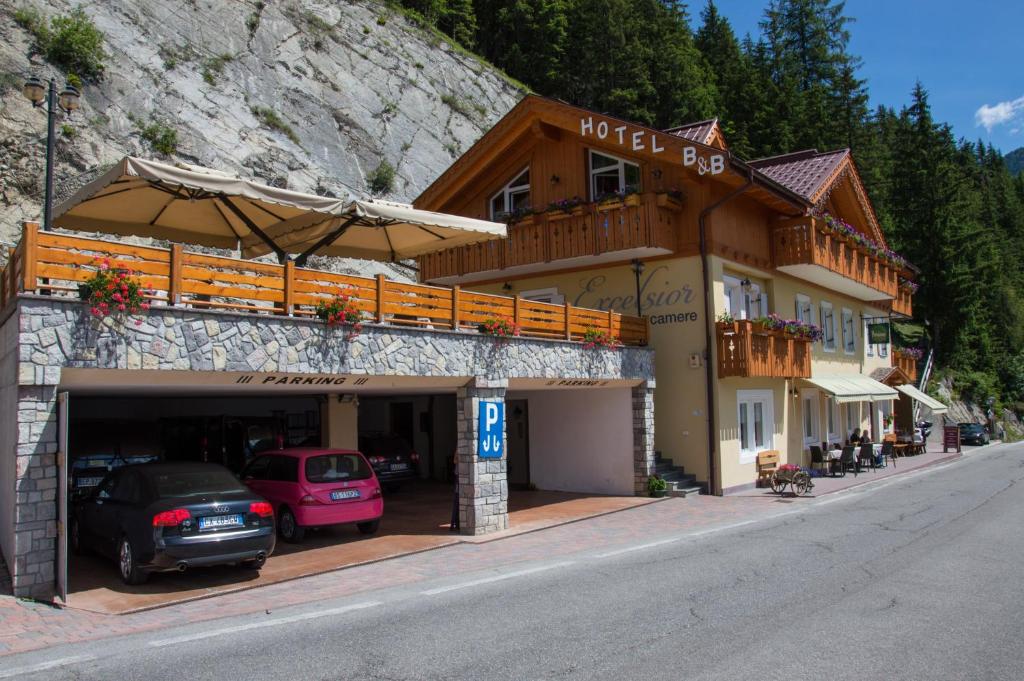 a hotel with cars parked in front of it at Hotel Garni Excelsior in Livinallongo del Col di Lana