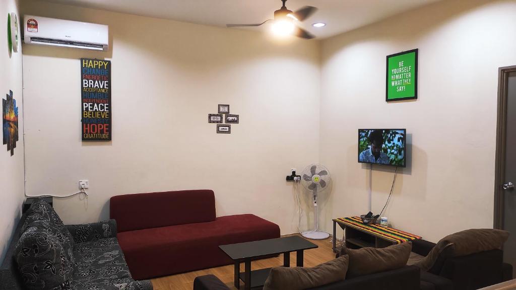 a living room with a couch and a tv at Hornbill Homestay Samarahan in Kota Samarahan