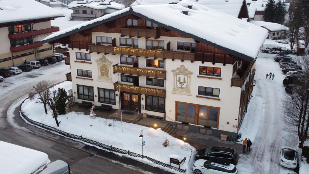 un grand bâtiment avec de la neige au sol dans l'établissement Altenmarkter Hof, à Altenmarkt im Pongau