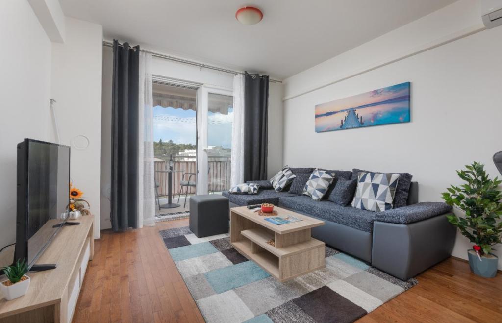 a living room with a couch and a tv at Sea View Apartment Michelle near Osejava in Makarska