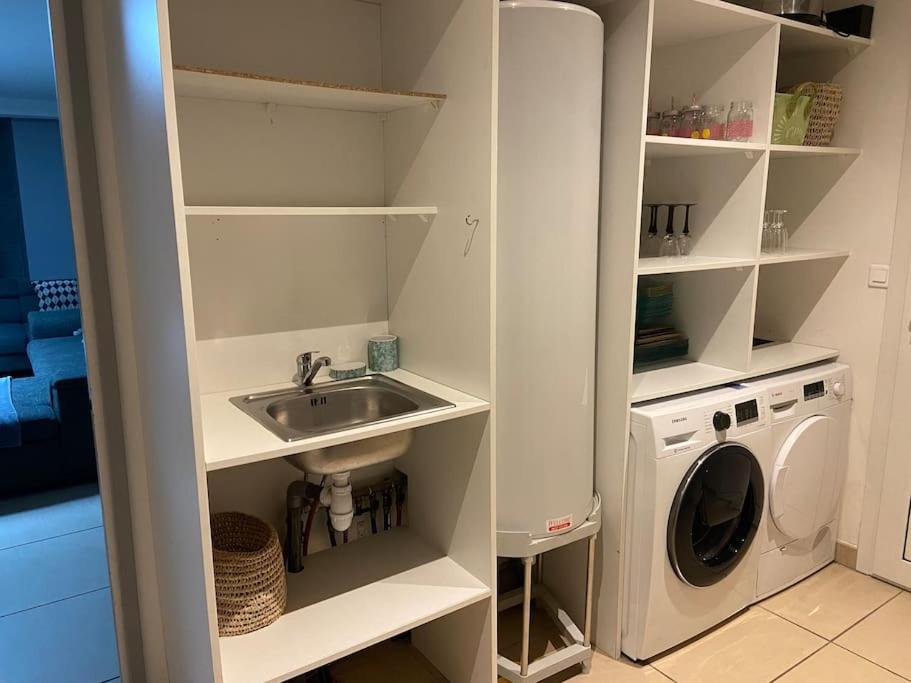 a white kitchen with a sink and a washing machine at Maison entre bordeaux et le bassin d&#39;arcachon avec piscine et jaccuzi 2 a 6 pers in Saint-Jean-dʼIllac