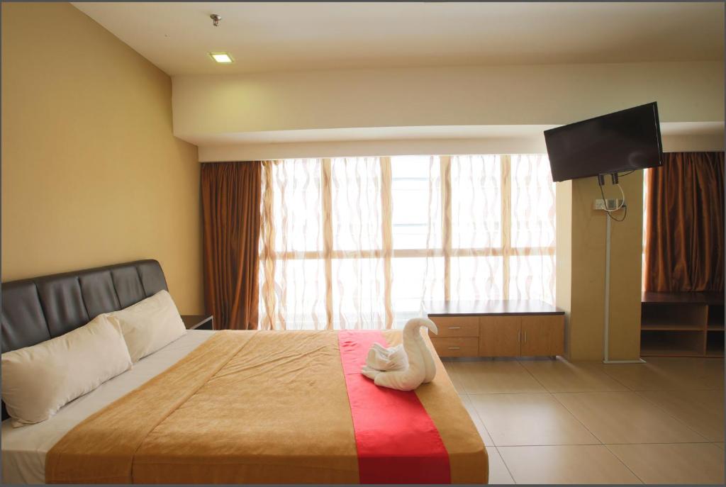 クアラルンプールにあるT Hotel Jalan Tarのベッドルーム1室(白鳥のおもちゃ付きのベッド1台付)