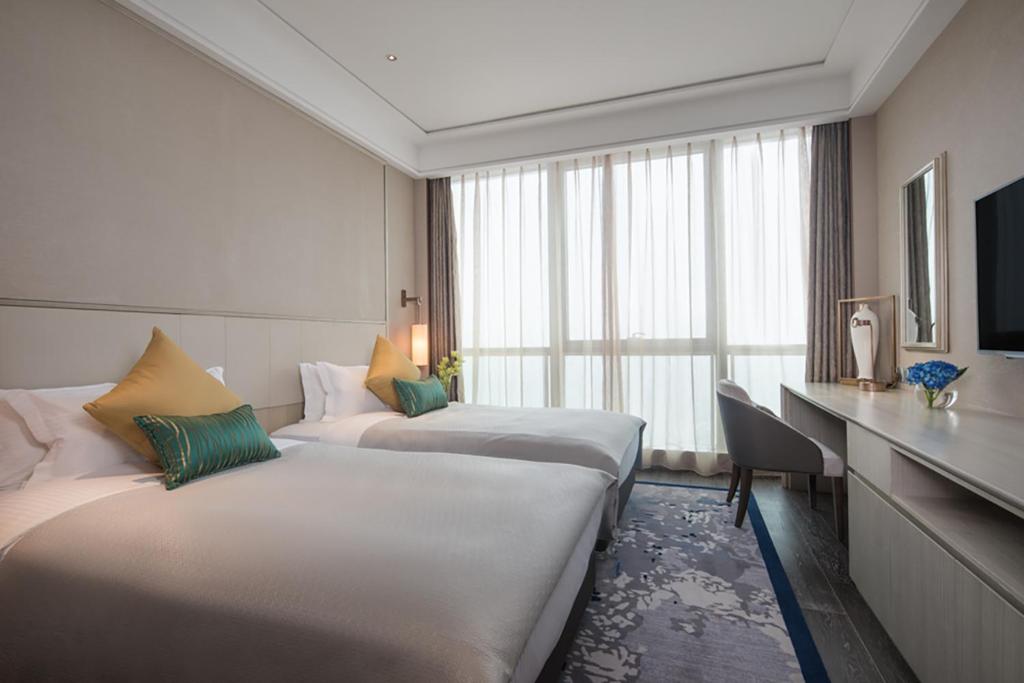 Letto o letti in una camera di Ascott Harmony City Nantong
