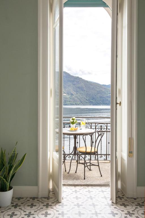 a room with a table and a view of the ocean at Villa Maria Boutique Apartments in Cannobio