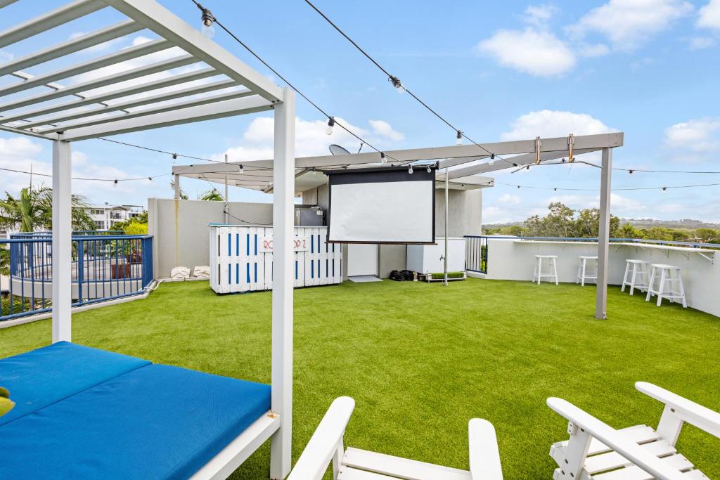 a large backyard with a screen on the roof of a house at The Penthouse Mooloolaba, Private Luxury Rooftop Living in Mooloolaba