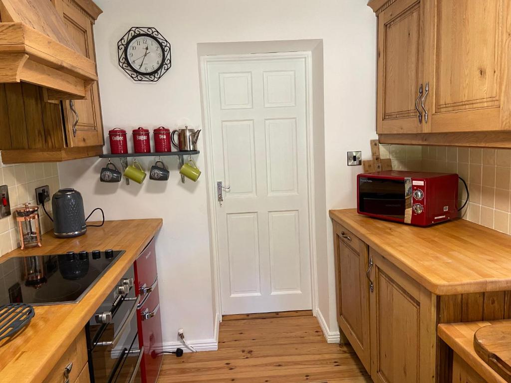 a kitchen with a white door and a red microwave at Rathjarney Gatelodge in Wexford