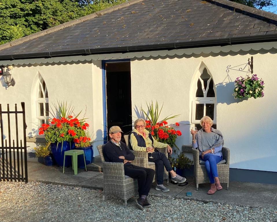 a group of people sitting in chairs outside of a church at Rathjarney Gatelodge in Wexford