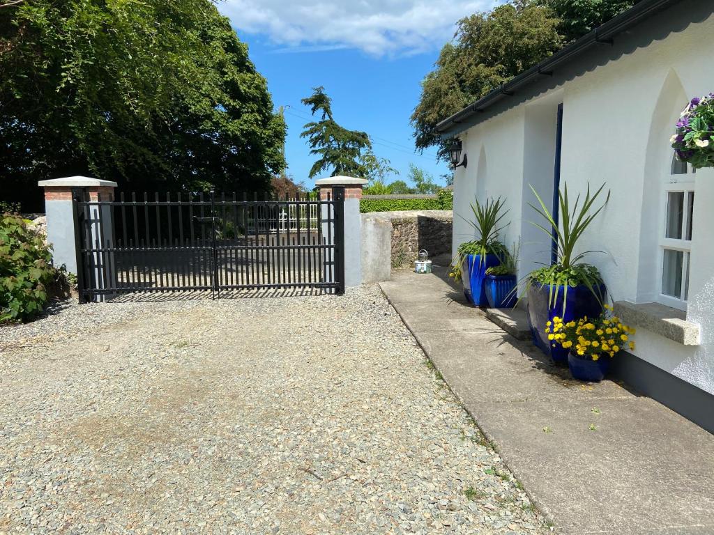 a gate to a house with flowers and plants at Rathjarney Gatelodge in Wexford