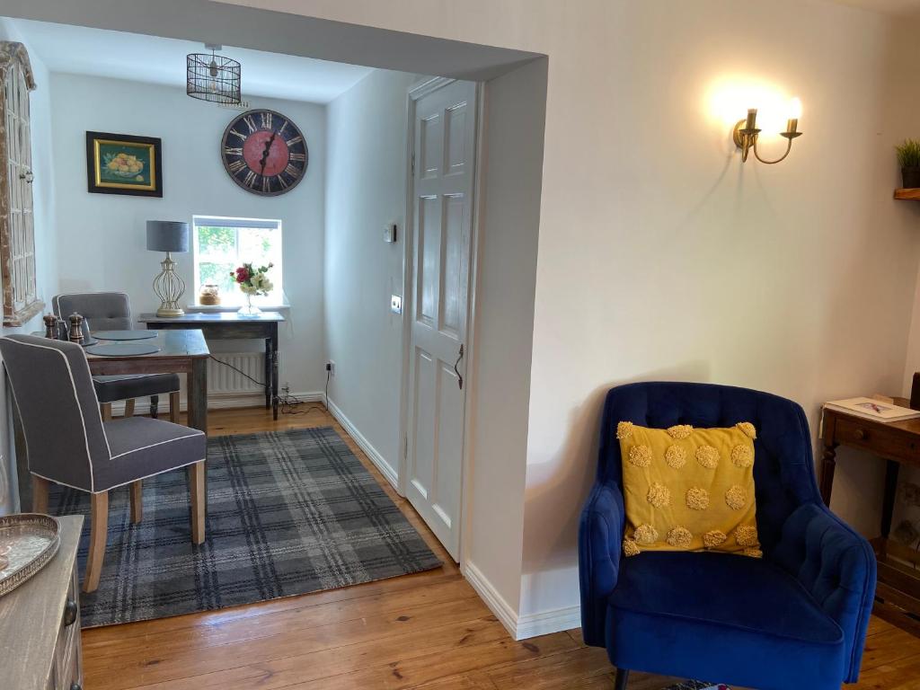 a living room with a blue chair and a table at Rathjarney Gatelodge in Wexford