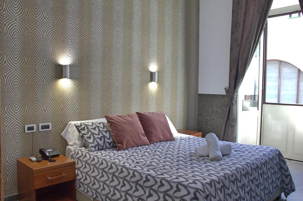 a bedroom with a large bed and a large window at Hotel Ciao in Rome
