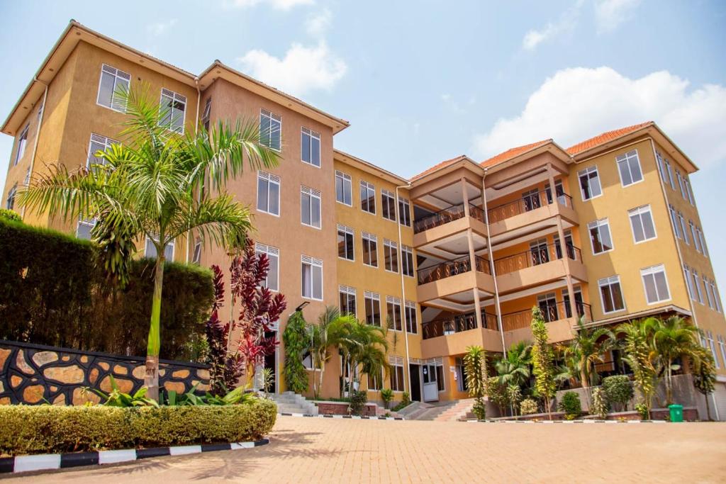 a row of apartment buildings with palm trees at Lishi Resort Hotel in Kampala
