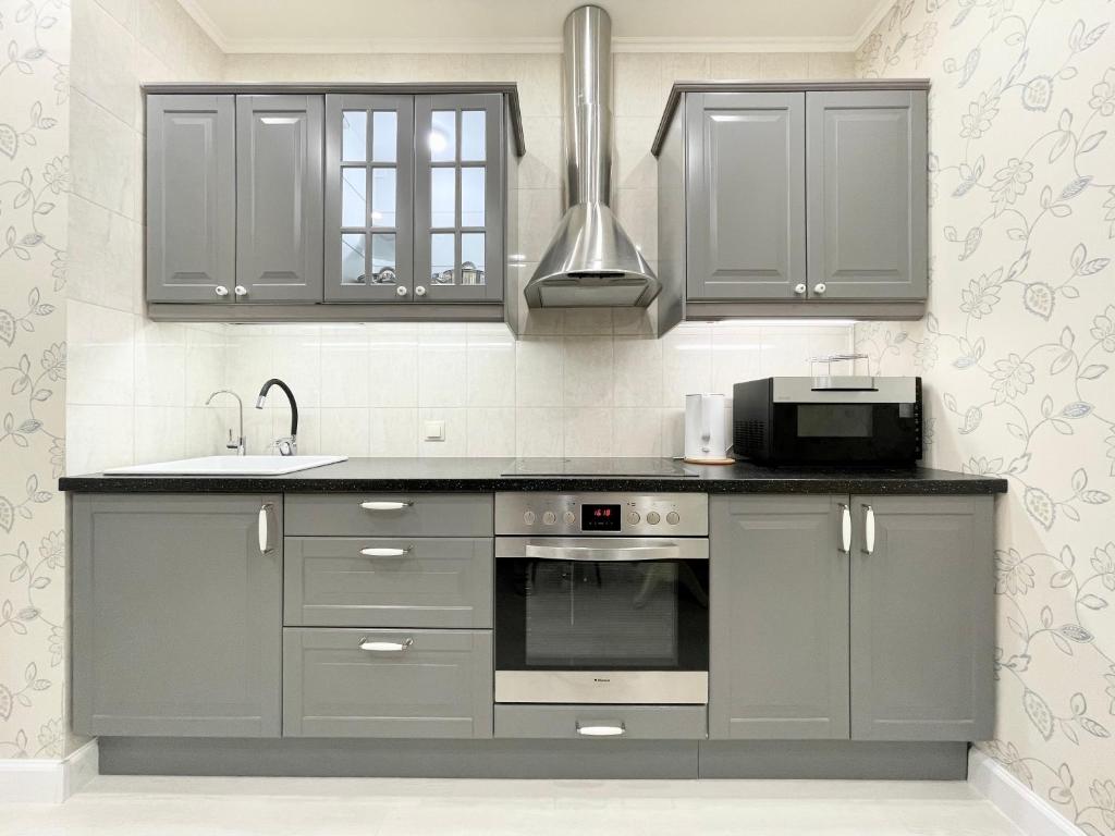 a kitchen with gray cabinets and a sink at Rauktis apartments in Saint Petersburg