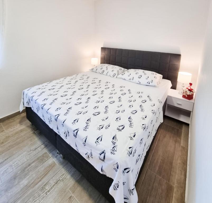 - une chambre avec un lit et une couette blanche dans l'établissement Apartment Ane 2, à Tisno