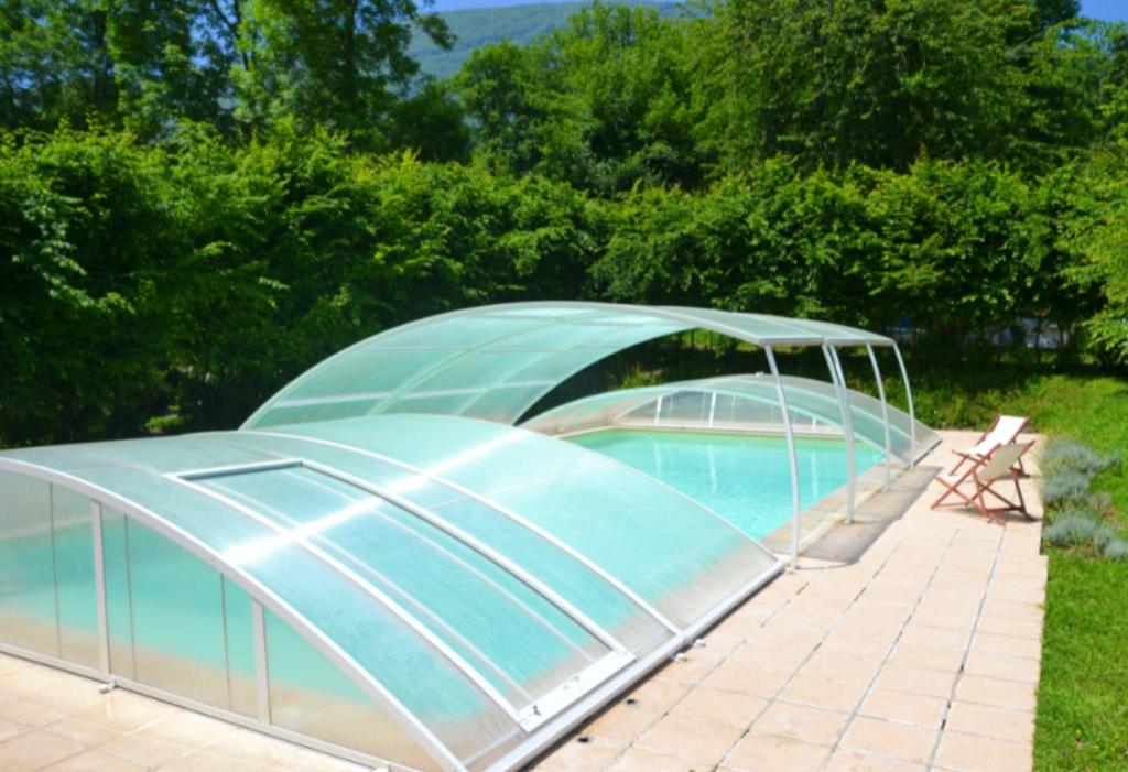 uma estufa com uma piscina num quintal em Maison de 2 chambres avec piscine partagee jardin clos et wifi a Gembrie em Gembrie