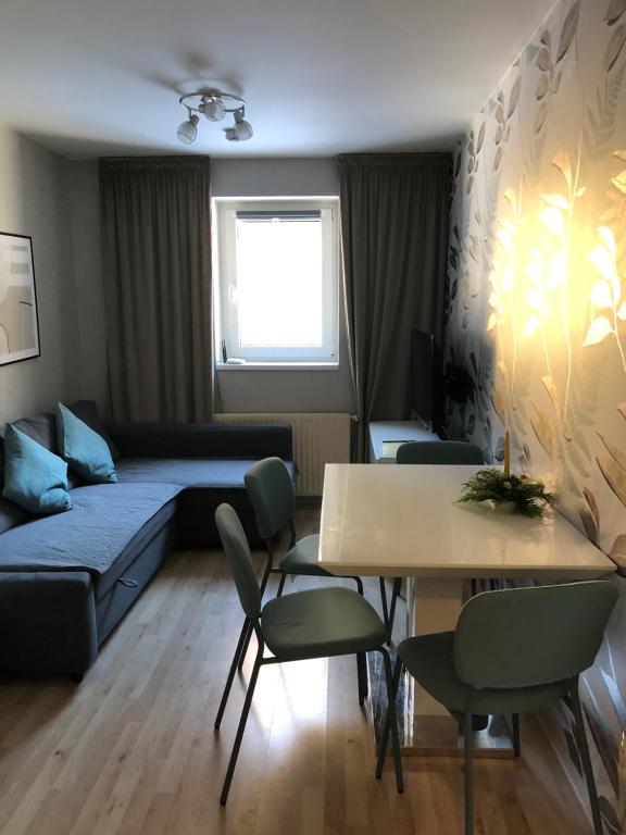 ein Wohnzimmer mit einem Sofa, einem Tisch und Stühlen in der Unterkunft Apartmán V Zeleni in Dolní Morava