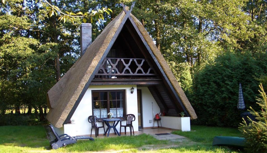 une petite maison blanche avec un toit triangulaire dans l'établissement Ferienhaus auf der Kauperinsel, à Burg