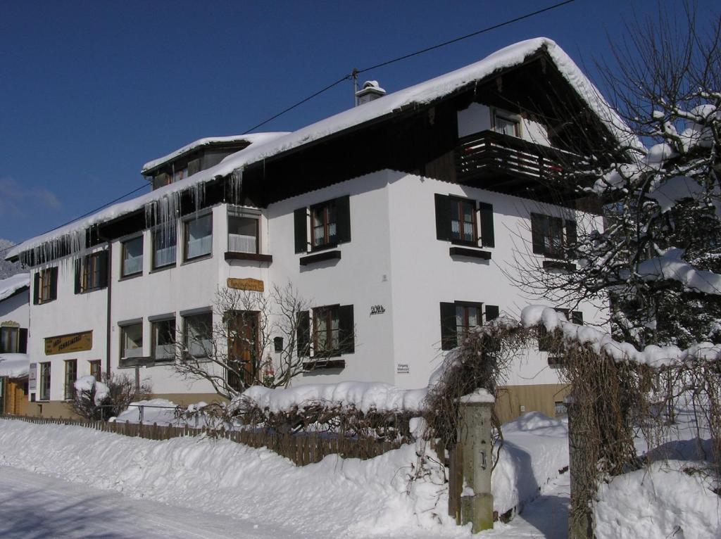 ein großes weißes Gebäude mit Schnee drauf in der Unterkunft Ferienwohnung Nöß in Pfronten