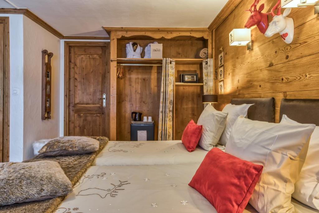 a bedroom with a large bed with red pillows at Les Monts Charvin in Courchevel