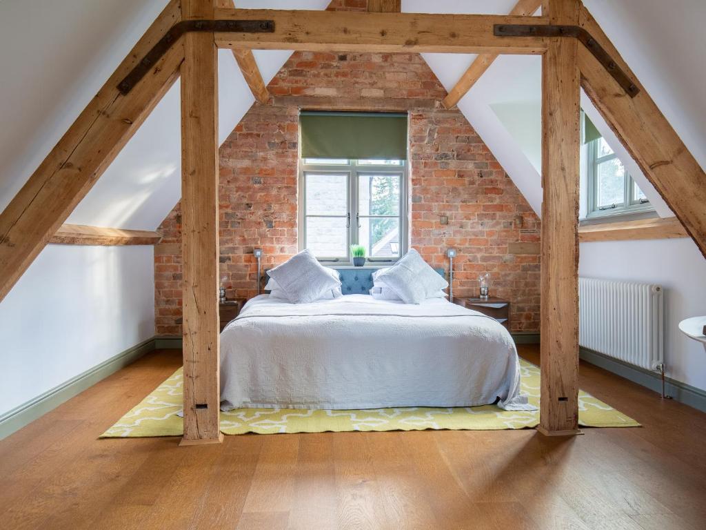 a bedroom with a bed in a brick wall at The Hayloft in Winchcombe