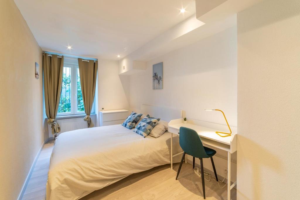 une chambre blanche avec un lit et un bureau dans l'établissement ❂ LES ROCHES ❂ CHIC ❂ CENTRE ❂ 6 PERS. ❂ RDC ❂ RBNB ❂, à Mulhouse