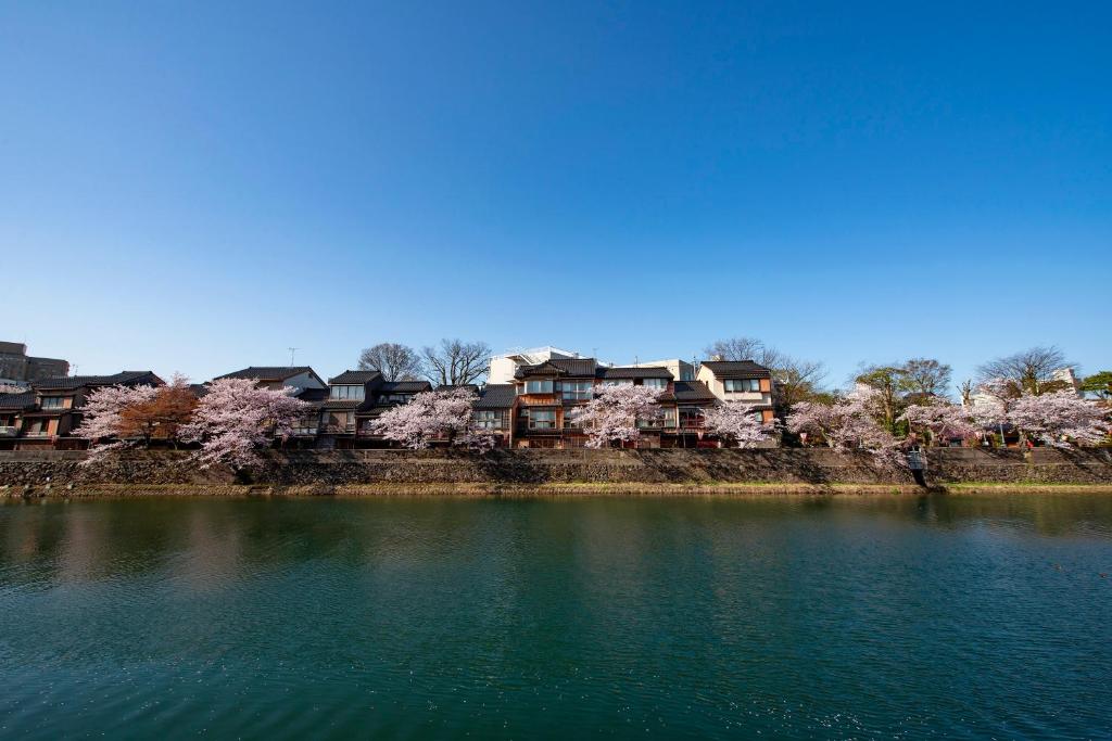 a large body of water with houses in the background at ANA Crowne Plaza Kanazawa by IHG in Kanazawa