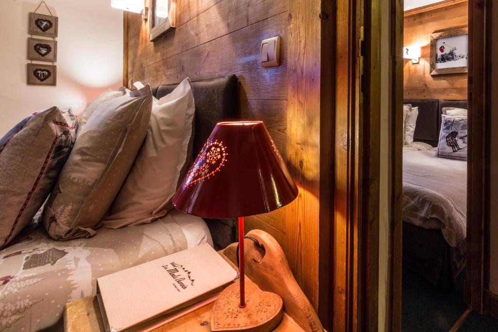 a red lamp on a table next to a bed at Les Monts Charvin in Courchevel
