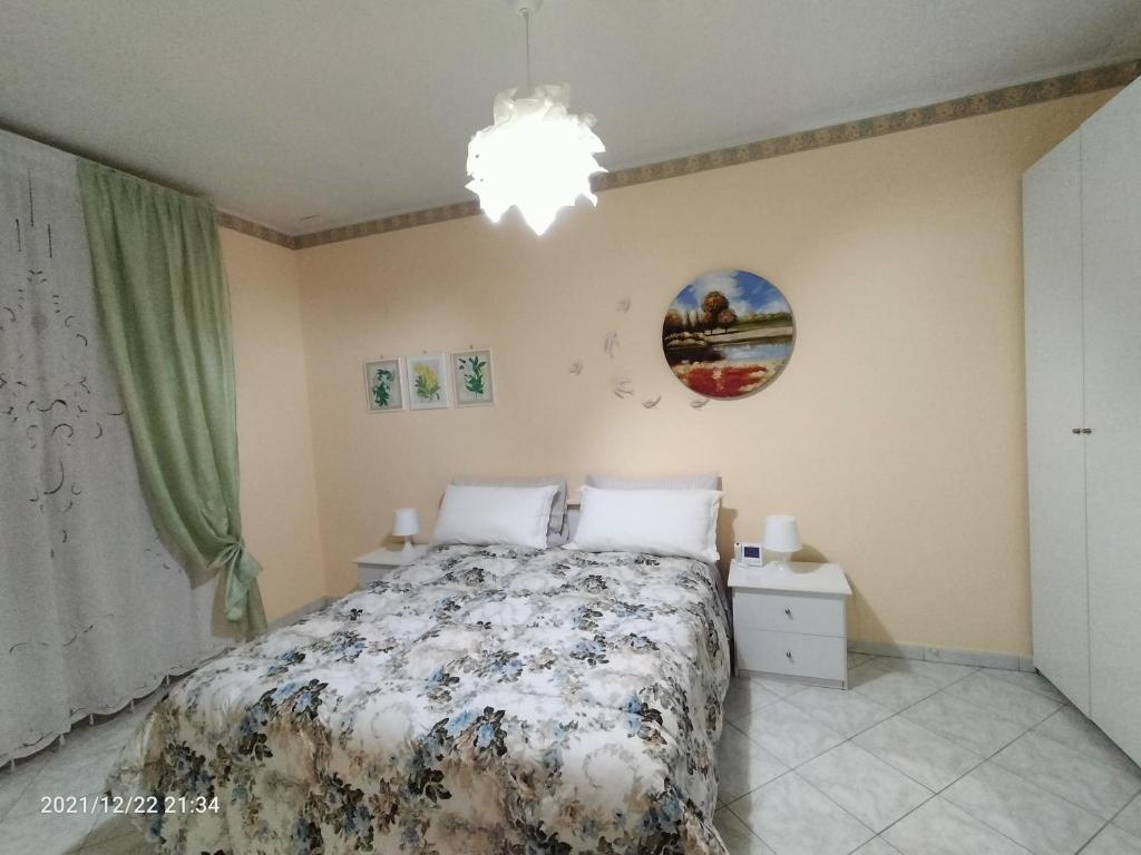 a bedroom with a bed and a chandelier at Beatrice Apartment con 1camera da letto, un soggiorno cucina e bagno in Scordia
