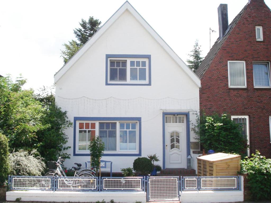 una casa blanca con una valla azul delante de ella en Villa-Husum, en Husum
