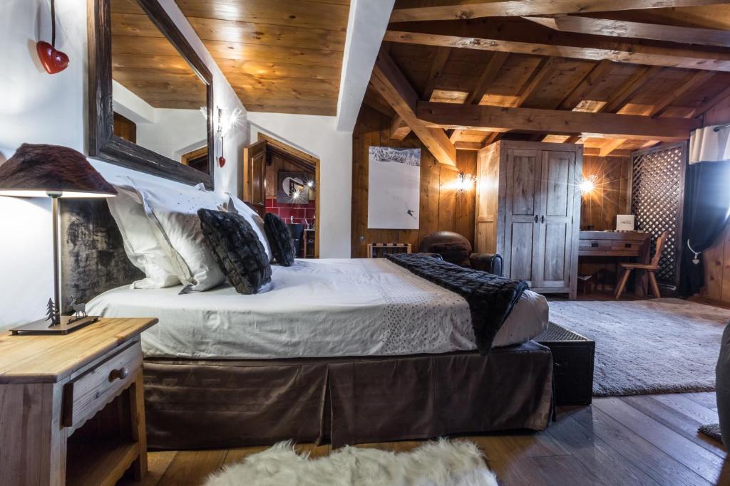 a bedroom with a large bed in a room with wooden ceilings at Les Monts Charvin in Courchevel