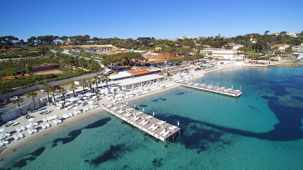 an aerial view of a beach with umbrellas and a dock at L'orangeraie du Cap d'Antibes in Antibes