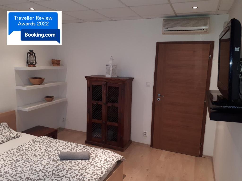 1 dormitorio con 1 cama y puerta de madera en Útulný apartmán v Bratislava 6 en Bratislava