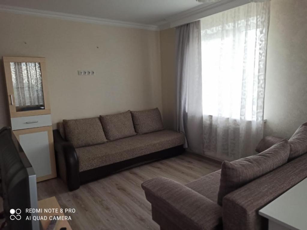 a living room with a couch and a window at Апартаменты на Московском проспекте in Kaliningrad