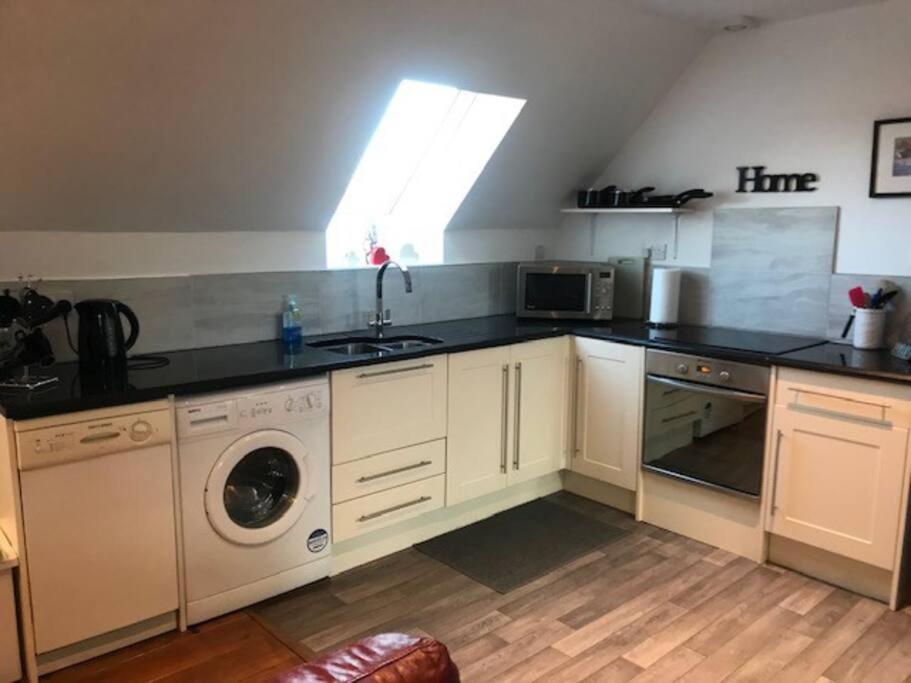 a kitchen with a sink and a washing machine at Castle View - Home from Home in Stirling