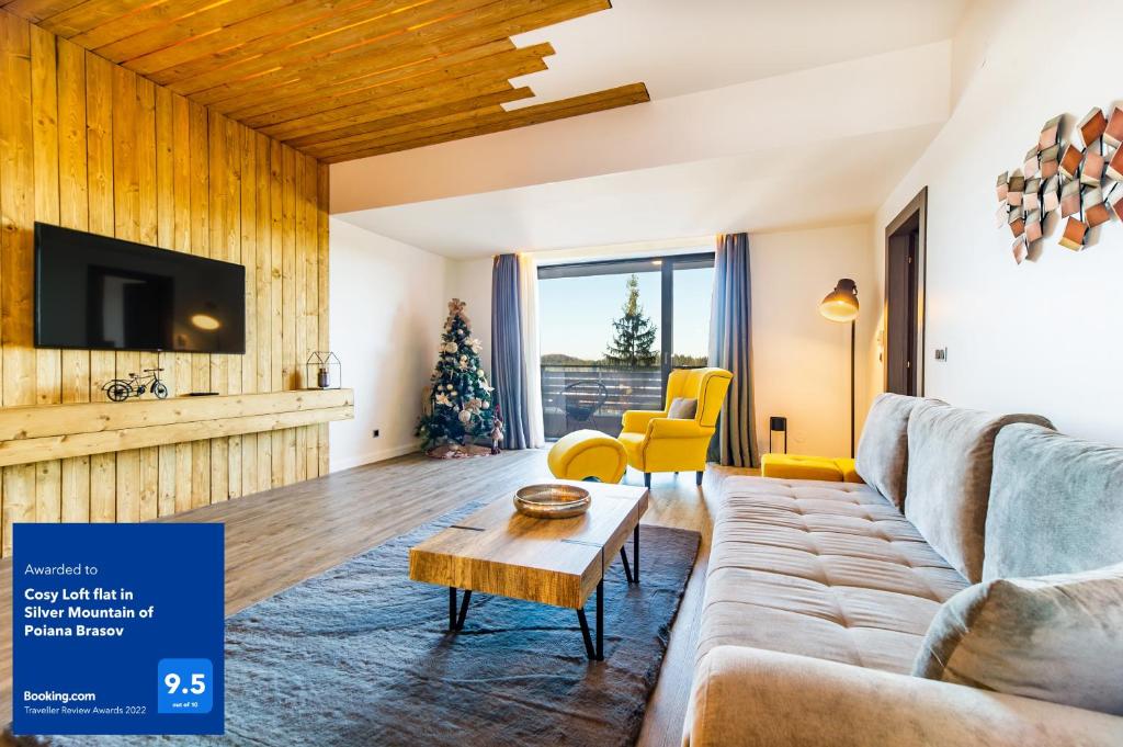 a living room with a couch and a table at Cosy Loft flat in Silver Mountain of Poiana Brasov in Poiana Brasov