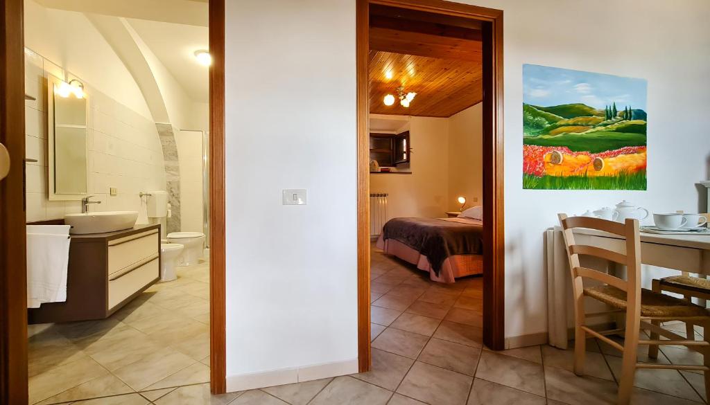a bathroom with a sink and a room with a bed at Agriturismo Barbadoro in San Vincenzo