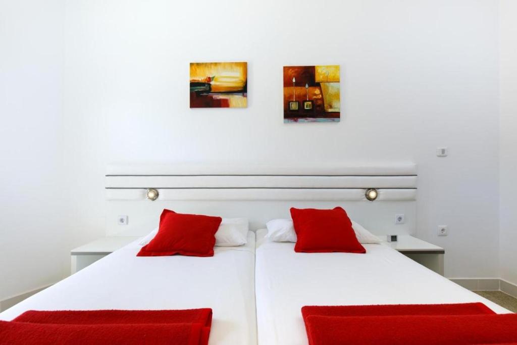 a bedroom with two beds with red pillows at Ark Beach Apartments next to the beach in Stobrec in Split