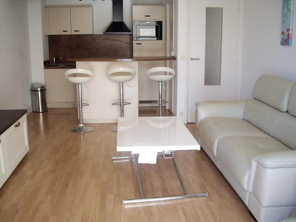ein Wohnzimmer mit einem Sofa und einem Tisch in der Unterkunft Appartement d'une chambre a Antibes a 250 m de la plage avec jardin clos et wifi in Antibes