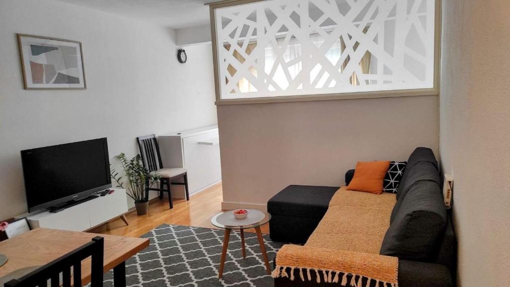 ein Wohnzimmer mit einem Sofa und einem TV in der Unterkunft Apartman HANA in Travnik