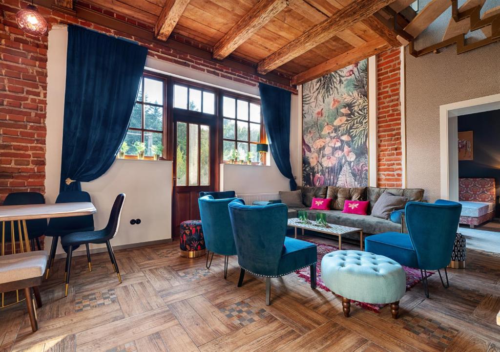 sala de estar con sillas azules y sofá en Rezydencja Julin Slow Life dla Gości 16+, en Wydrze