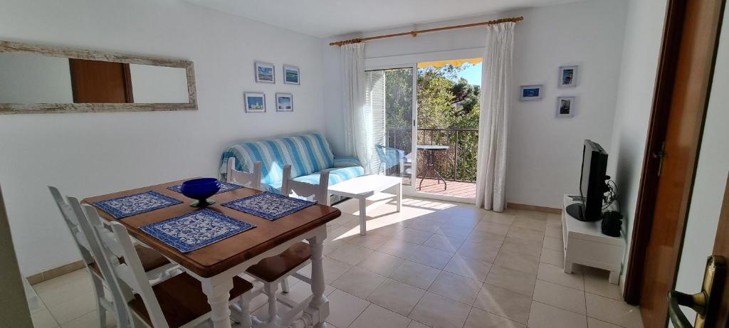 a dining room with a table and chairs and a television at Sa Shei Apartment Tossa de Mar in Tossa de Mar