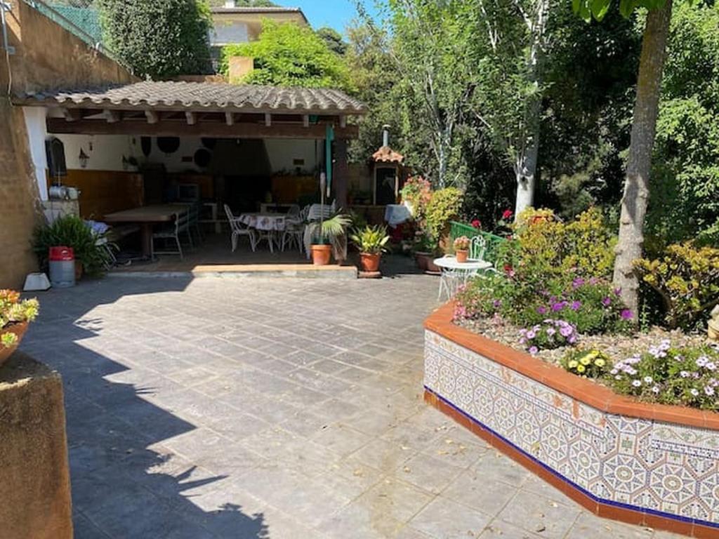 a patio with a table and chairs in a yard at Canyelles BBQ Apartment in Lloret de Mar
