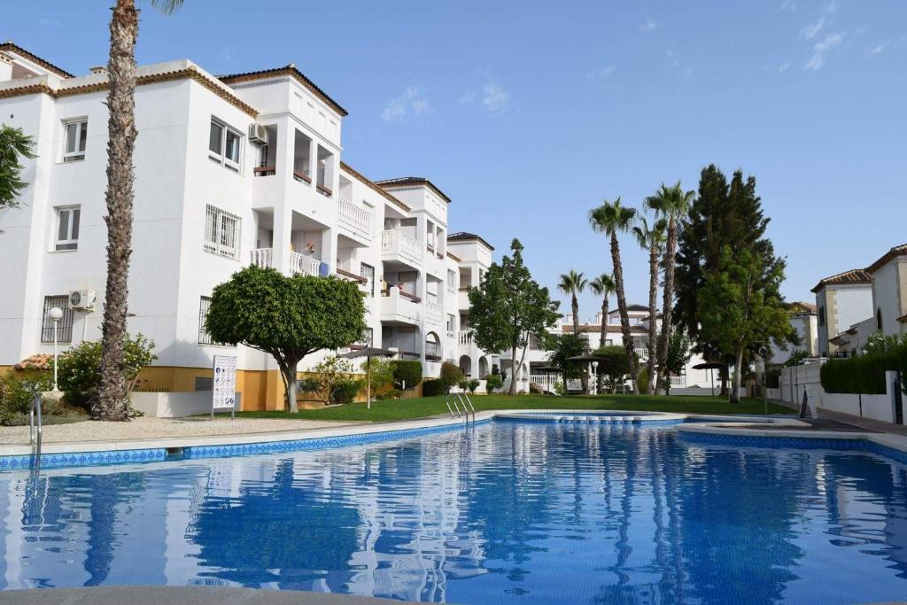 a swimming pool in front of some apartment buildings at FABULOUS 2 BED 2 BATH APARTMENT ! in Villamartin