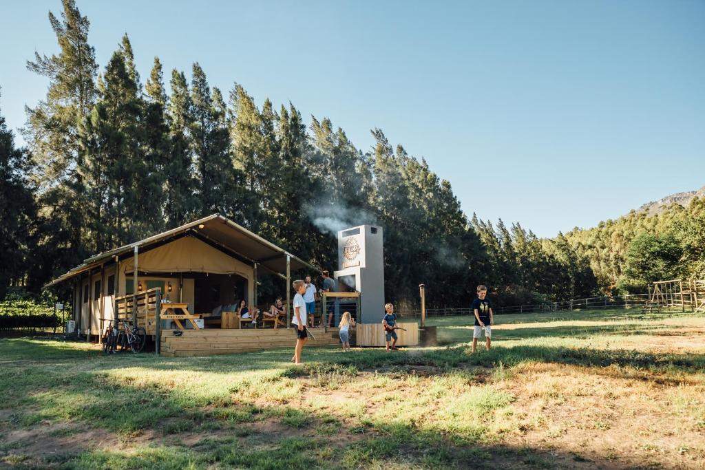 un groupe de personnes debout devant un bâtiment dans l'établissement AfriCamps at Doolhof Wine Estate, à Wellington