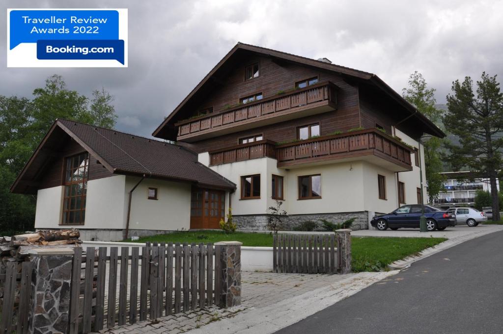 a large wooden house with a fence in front of it at Podkrovný apartmán v Smokovec in Vysoke Tatry - Novy Smokovec