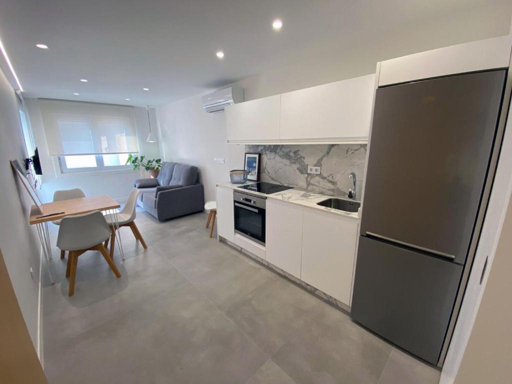 kuchnia z lodówką i stołem z jadalnią w obiekcie Apartamentos Angelito Playa América A w mieście Nigrán