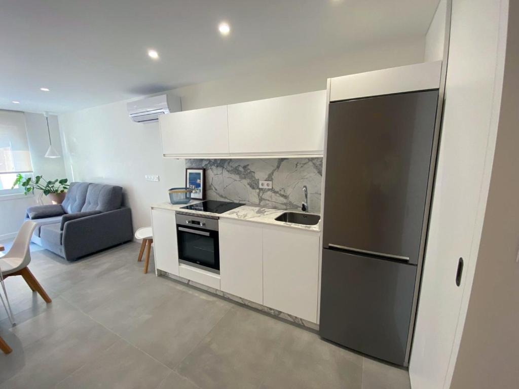 kuchnia z czarną lodówką i salon w obiekcie Apartamentos Angelito Playa América A w mieście Nigrán